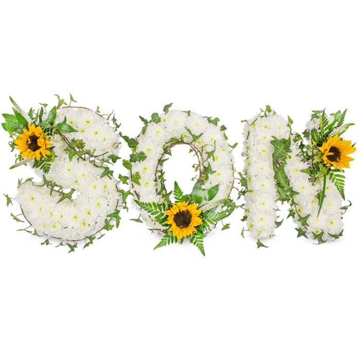 A three-dimensional memorial display spells the word SON in strong capital lettering, each form painstakingly built from hundreds of small, pristine white chrysanthemums to create a dense, velvety texture across every curve and angle. Dark green ivy vines are woven through the letters, their trailing tendrils and glossy lobed leaves adding linear rhythm and a living contrast to the pure white floral mass. Complementing the white and green palette are three clear focal sunflowers with broad yellow rays and dark brown, textural centres: one placed on the upper-left curve of the S, one seated at the bottom centre of the O amidst layers of fern fronds and pointed leaves, and a third positioned at the upper-right of the N. The ferns and pointed foliage supply fine, soft textures and cooler green tones that help the letters read with depth when viewed straight-on or slightly oblique. The arrangement is photographed against a stark white background beneath soft studio illumination, so the chrysanthemum clusters, sunflower discs, and the veins of the ivy leaves are sharply visible, with subtle shadows that give the piece volume. This bespoke funeral tribute balances traditional bereavement symbolism - white for peace, green for life - with the sunflower's suggestion of warmth and remembrance, making it an apt choice for commemorating a beloved son. As an experienced florist working near Fortis Green Road and the surrounding neighbourhoods, I would describe this as a composed, respectful design meant to communicate love, permanence and the gentle promise of memory.